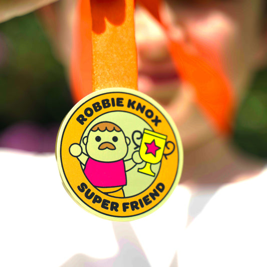 Medal with 'Robbie Knox Super Friend' text and cartoon version of Robbie